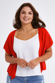 Model Monique wearing size L of The Short Sleeve Shrug in colour Red (Red), from the front, cropped image