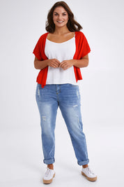 Model Monique wearing size L of The Short Sleeve Shrug in colour Red (Red), from the front, showing the whole outfit