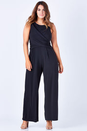 Model Laura wearing size 12 of The Cross Waist Jumpsuit in colour Black (Black), from the front, showing the whole outfit