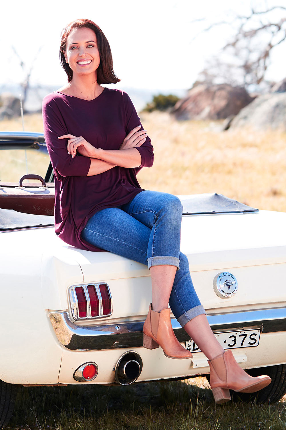 Model Perrie wearing size 10 of The V Neck Side Drape Tee in colour Wine (Purple), from the front, showing the whole outfit