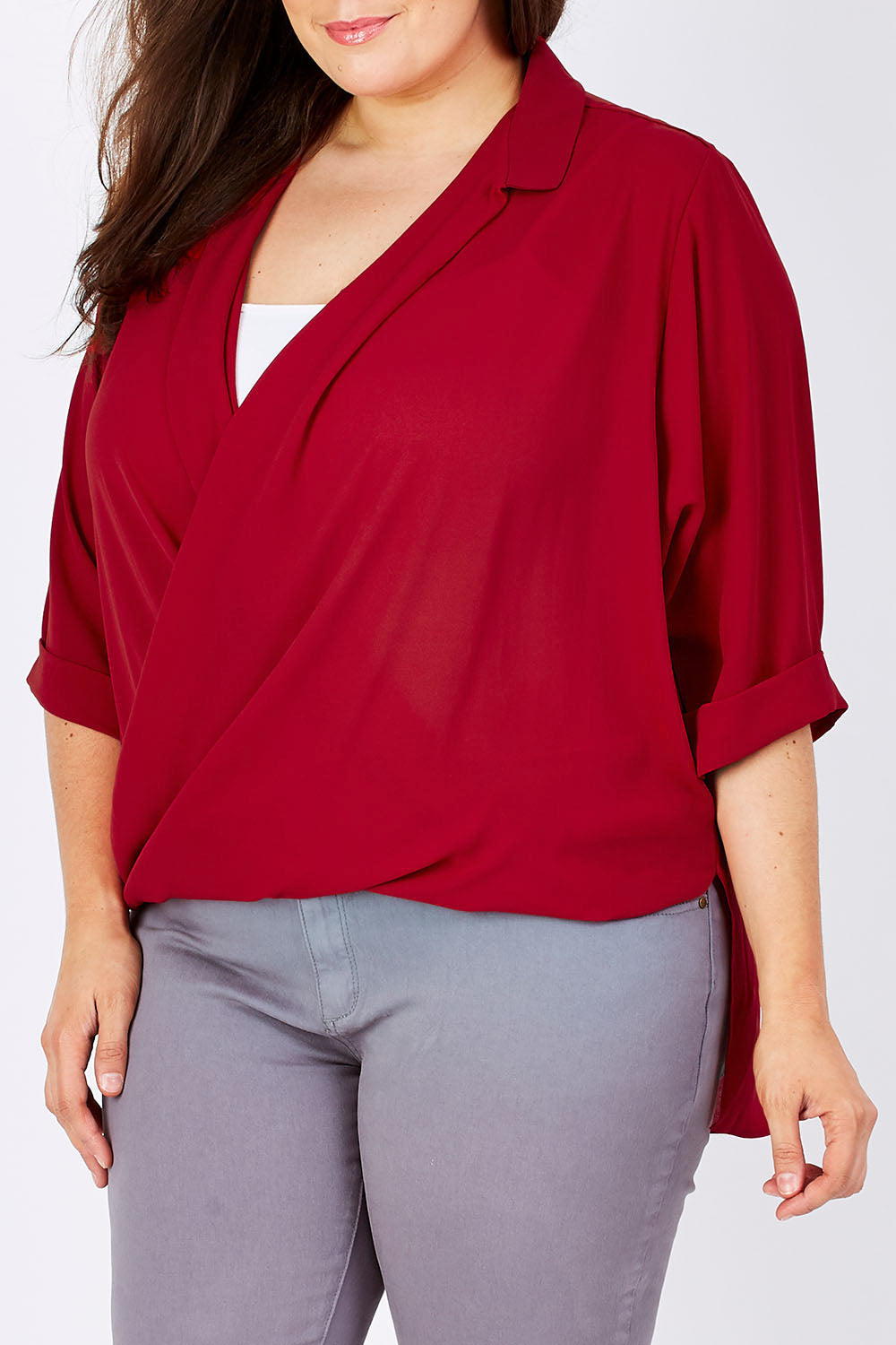 Model Mae wearing size 16 of The Cross Over Blouse in colour Red (Red), from the front, cropped image