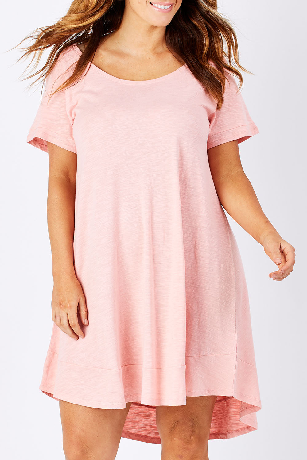 Model Mae wearing size 16 of The Swing Dress in colour Pink (Pink), from the front, cropped image