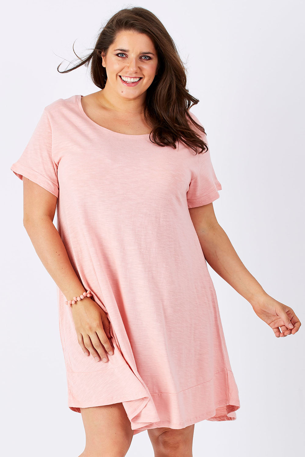 Model Mae wearing size 16 of The Swing Dress in colour Pink (Pink), from the front, cropped image