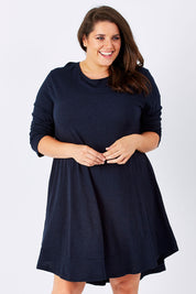 Model Mae wearing size 18 of The Long Sleeve Swing Dress in colour Navy (Blue), from the front, cropped image