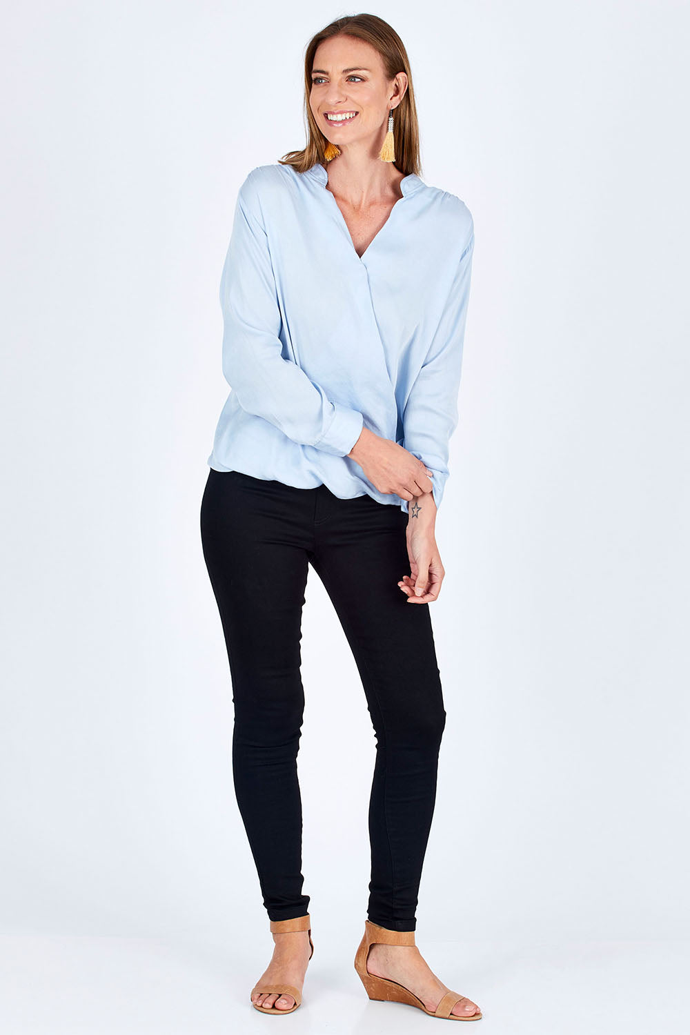 Model Riina wearing size 10 of The Daily Cross Over Top in colour SkyBlue (Blue), from the front, showing the whole outfit