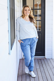 A model wearing size 14 of The Pull On Jogger Jean in colour Denim (Blue), from the front, showing the whole outfit