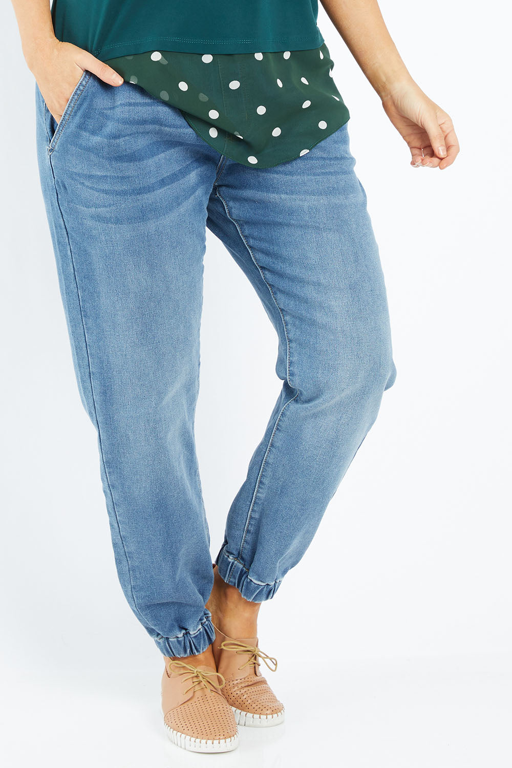 Model Laura wearing size 14 of The Pull On Jogger Jean in colour Denim (Blue), from the front, cropped image