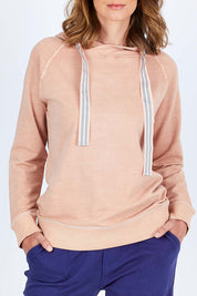 Model Riina wearing size 10 of The Tie Detail Hoody in colour Pink (Black), from the front, cropped image