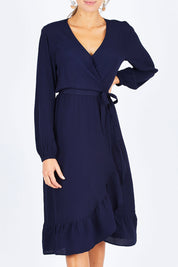 Model Madeline wearing size 10 of The Midi Wrap Dress in colour Navy (Black), from the front, cropped image