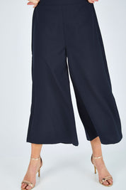 Model Chelsea wearing size 10 of The Keepsake Culotte in colour Navy (Blue), from the front, cropped image