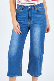 Model Chelsea wearing size 10 of The Wide Leg Jean in colour Denim (Blue), from the front, cropped image