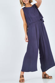 Model Chelsea wearing size 10 of The Overlay Jumpsuit in colour Navy (Blue), from the front, cropped image