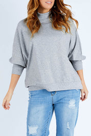 Model Laura wearing size L of The Batwing Jumper in colour Greyfleck (Grey), from the front, cropped image