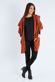 Model Anna wearing size OneSize of The Oversized Cape in colour Rust, from the front, showing the whole outfit
