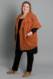 Model Sarah wearing size OneSize of The Oversized Cape in colour Rust, from the front, showing the whole outfit
