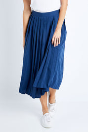 Model Anna wearing size 10 of The Pleated Skirt in colour Navy (Blue), from the front, cropped image