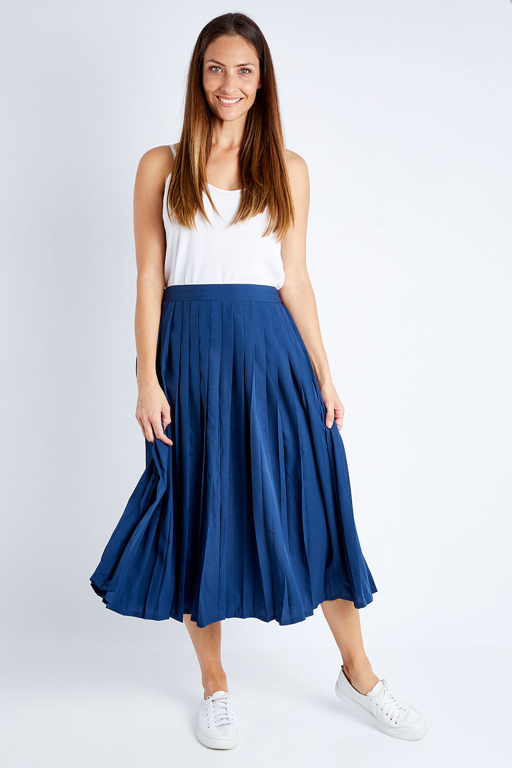 Model Anna wearing size 10 of The Pleated Skirt in colour Navy (Blue), from the front, showing the whole outfit