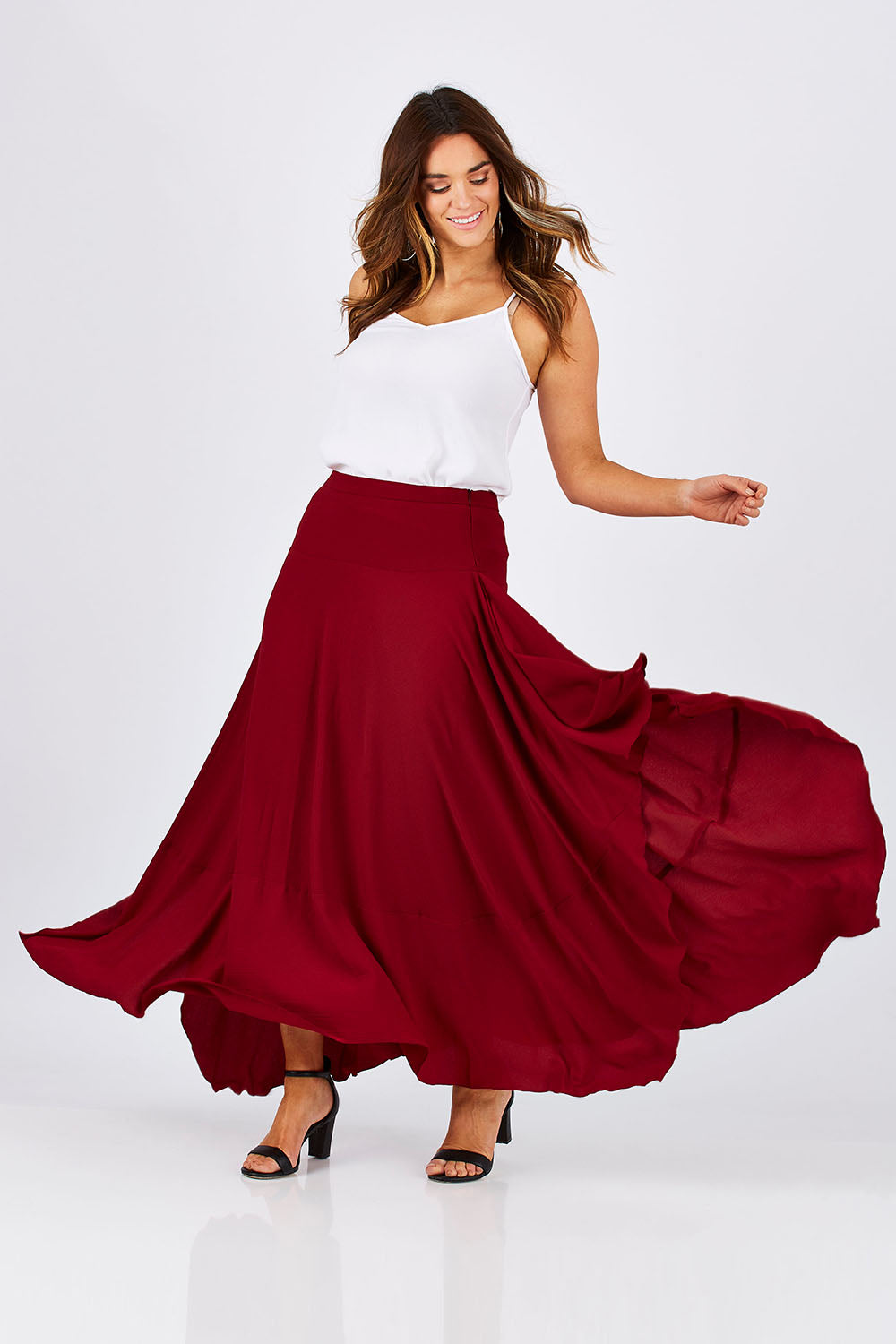 Model Laura wearing size 12 of The Flowy Skirt in colour Apple (Red), from the front, showing the whole outfit