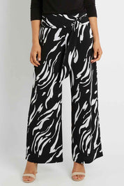 Model Pamela wearing size 10 of The Printed Travel Pant in colour Abstract (Black), from the front, cropped image