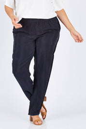 Model Mae wearing size 18 of The Curve Hem Pant in colour Ink (Blue), from the front, cropped image