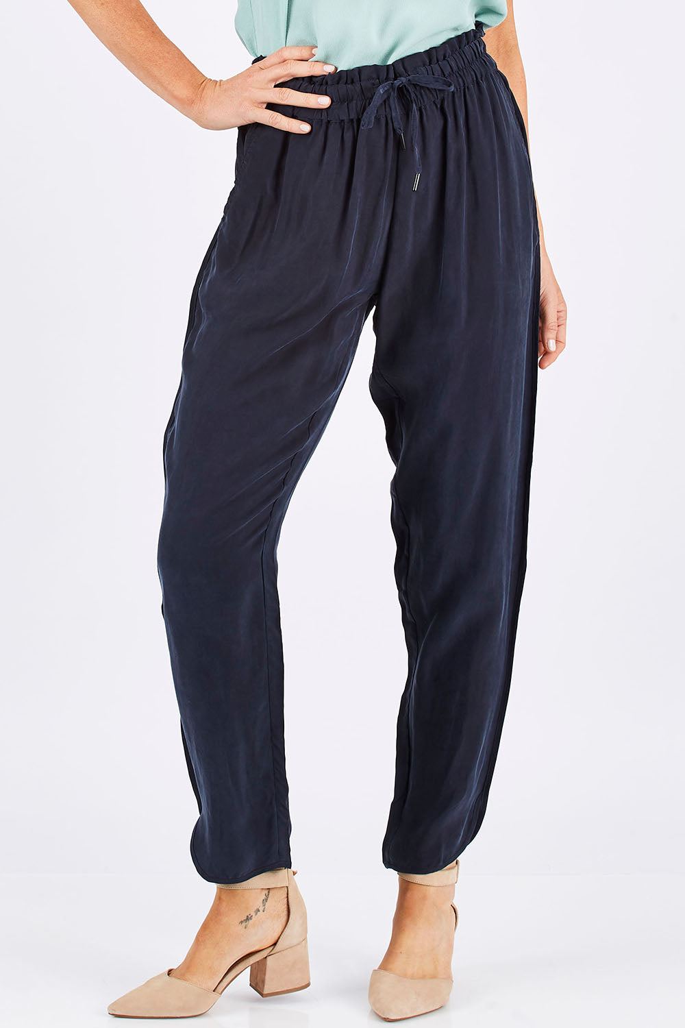 Model Monique wearing size 8 of The Curve Hem Pant in colour Ink (Blue), from the front, cropped image