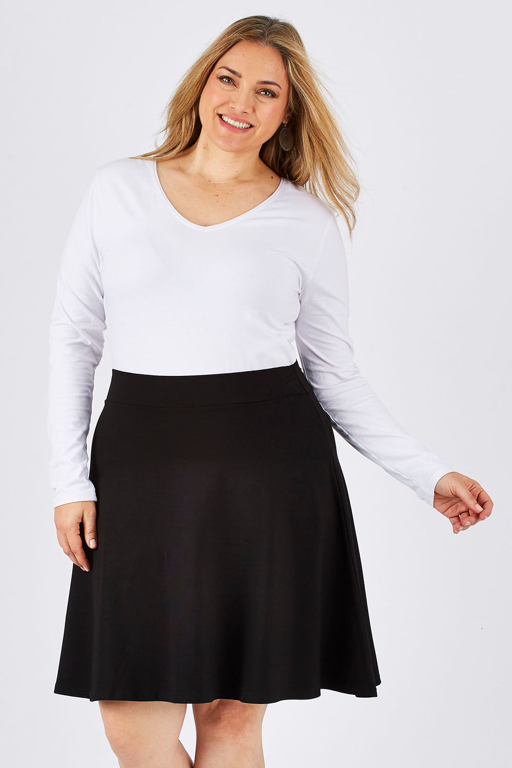 Model Ljubenka wearing size 18 of The Ponte Flip Skirt in colour Black (Black), from the front, cropped image