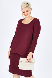 Model Stefania wearing size 14 of The Long Rita Dress in colour Port (Purple), from the front, cropped image