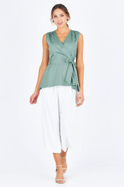 Model Madeline wearing size 10 of The Sleeveless Cotton Wrap Top in colour Sage (Green), from the front, showing the whole outfit