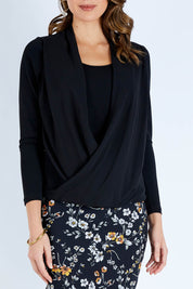 Model Madeline wearing size 10 of The Faux 2 Piece Crossover Top in colour Black (Black), from the front, cropped image