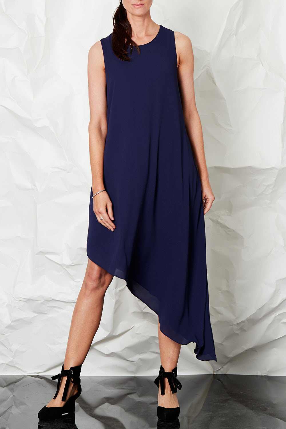 Model Anneliese wearing size 8 of the By Design in colour Slant Hem Dress - Navy (Blue), from the front, cropped image