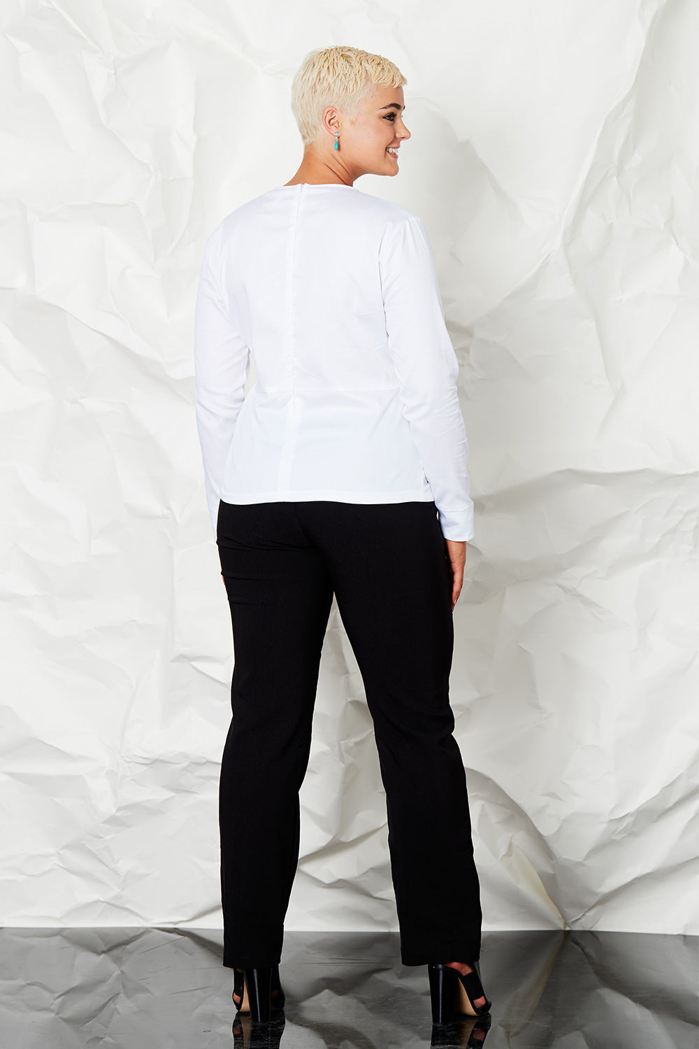 Model Rebecca wearing size 14 of the Knot Blouse in colour White (White), from the back