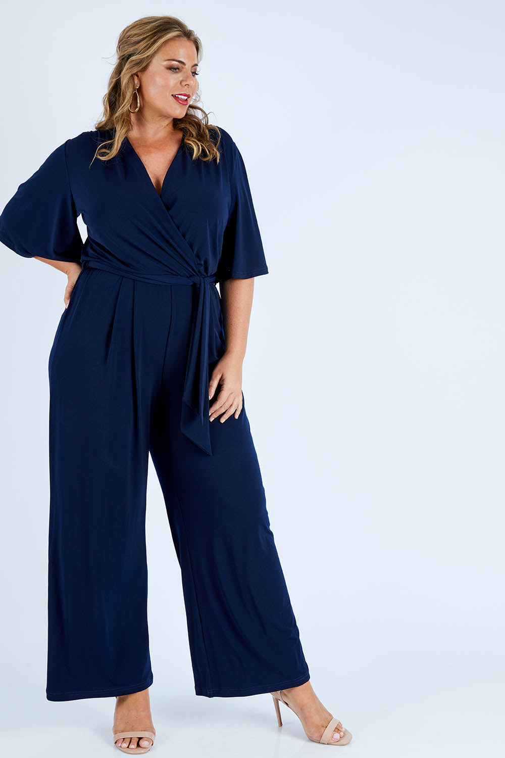 Model Fiona wearing size 16 of The Bell Sleeve Jumpsuit in colour Navy (Blue), from the front, showing the whole outfit