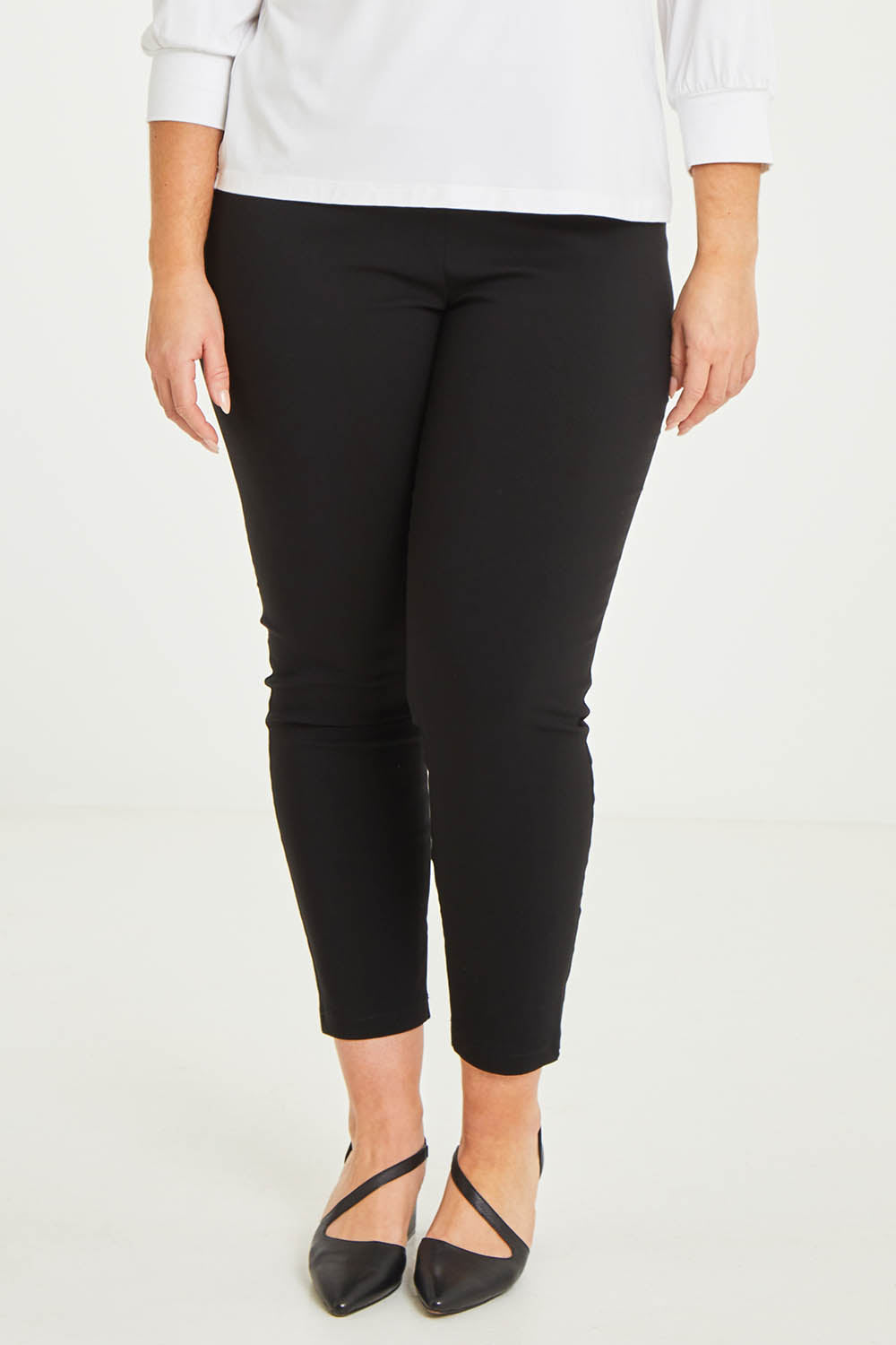 Model Katie wearing size 16 of The Stretch Career Pull On Pant in colour Black (Black), from the front, cropped image