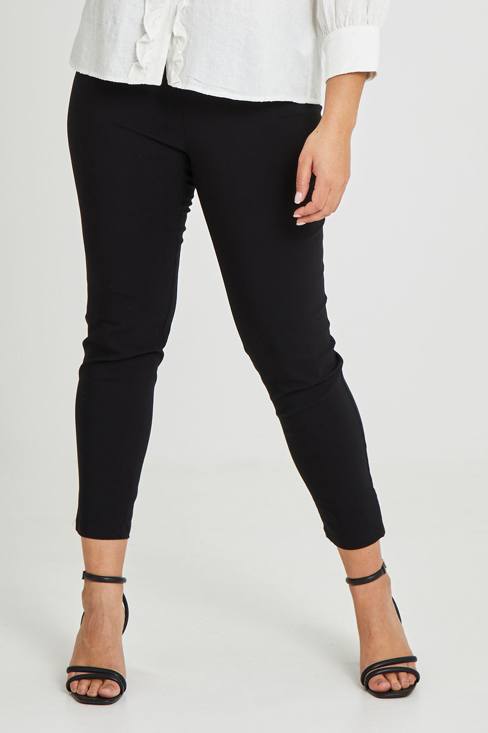 Model Terri-Leigh wearing size 14 of The Stretch Career Pull On Pant in colour Black (Black), from the front, cropped image