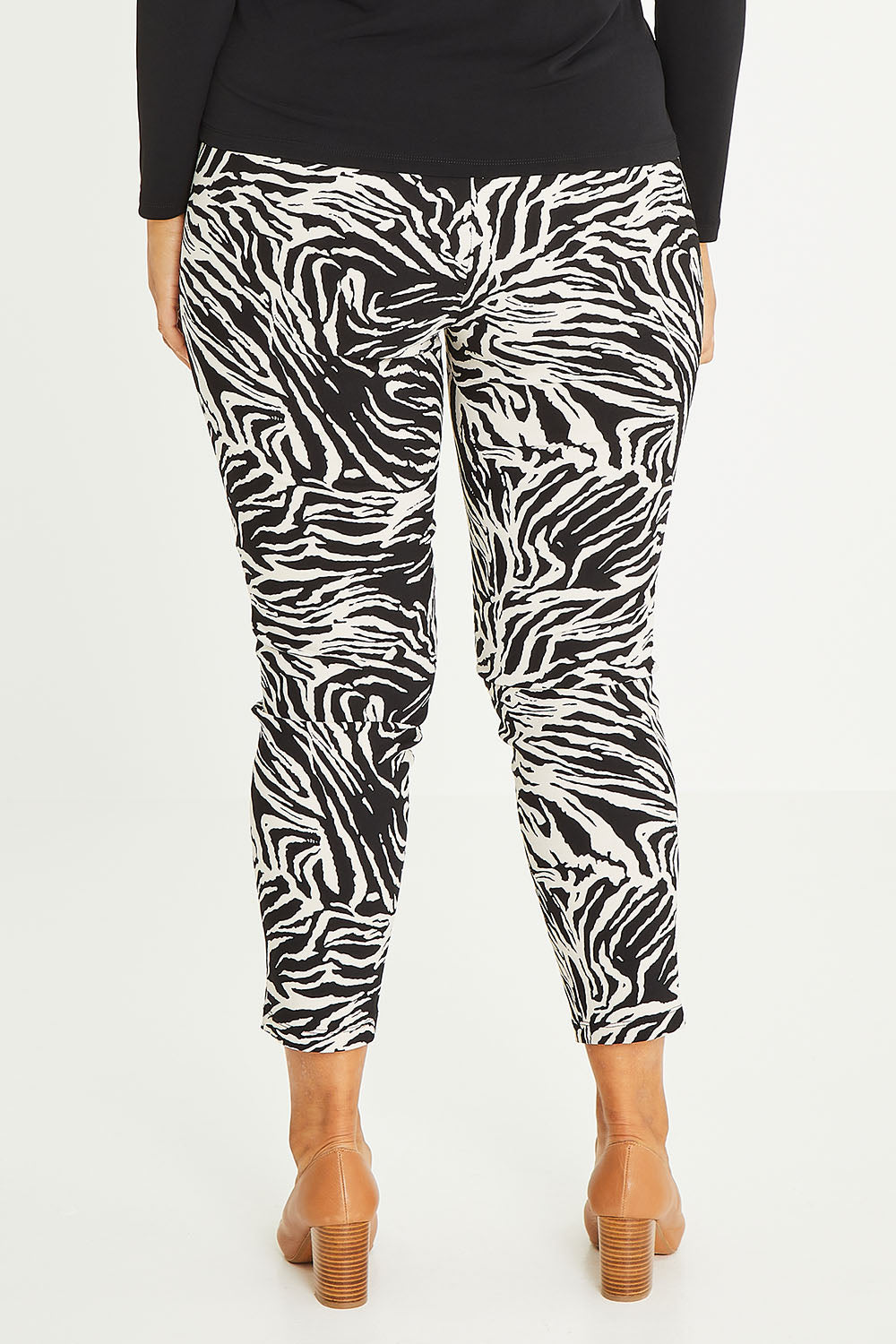 Model Palatina wearing size 16 of The Printed Pull On Pant in colour Zebra (Black), from the back
