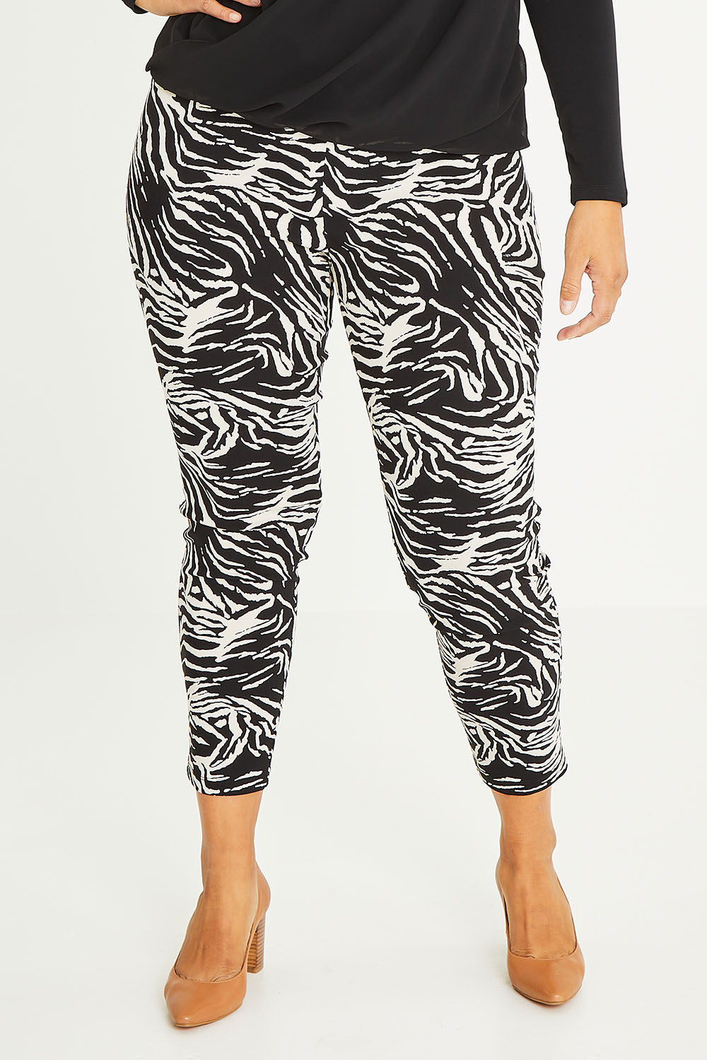 Model Palatina wearing size 16 of The Printed Pull On Pant in colour Zebra (Black), from the front, cropped image