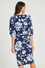 Model Madeline wearing size 10 of The Printed Knot Waist Detail Dress in colour Navyfleur (Blue), from the back
