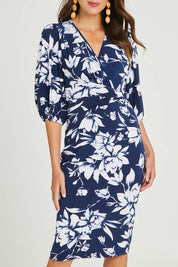 Model Madeline wearing size 10 of The Printed Knot Waist Detail Dress in colour Navyfleur (Blue), from the front, cropped image
