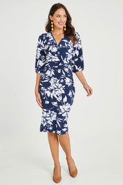 Model Madeline wearing size 10 of The Printed Knot Waist Detail Dress in colour Navyfleur (Blue), from the front, showing the whole outfit