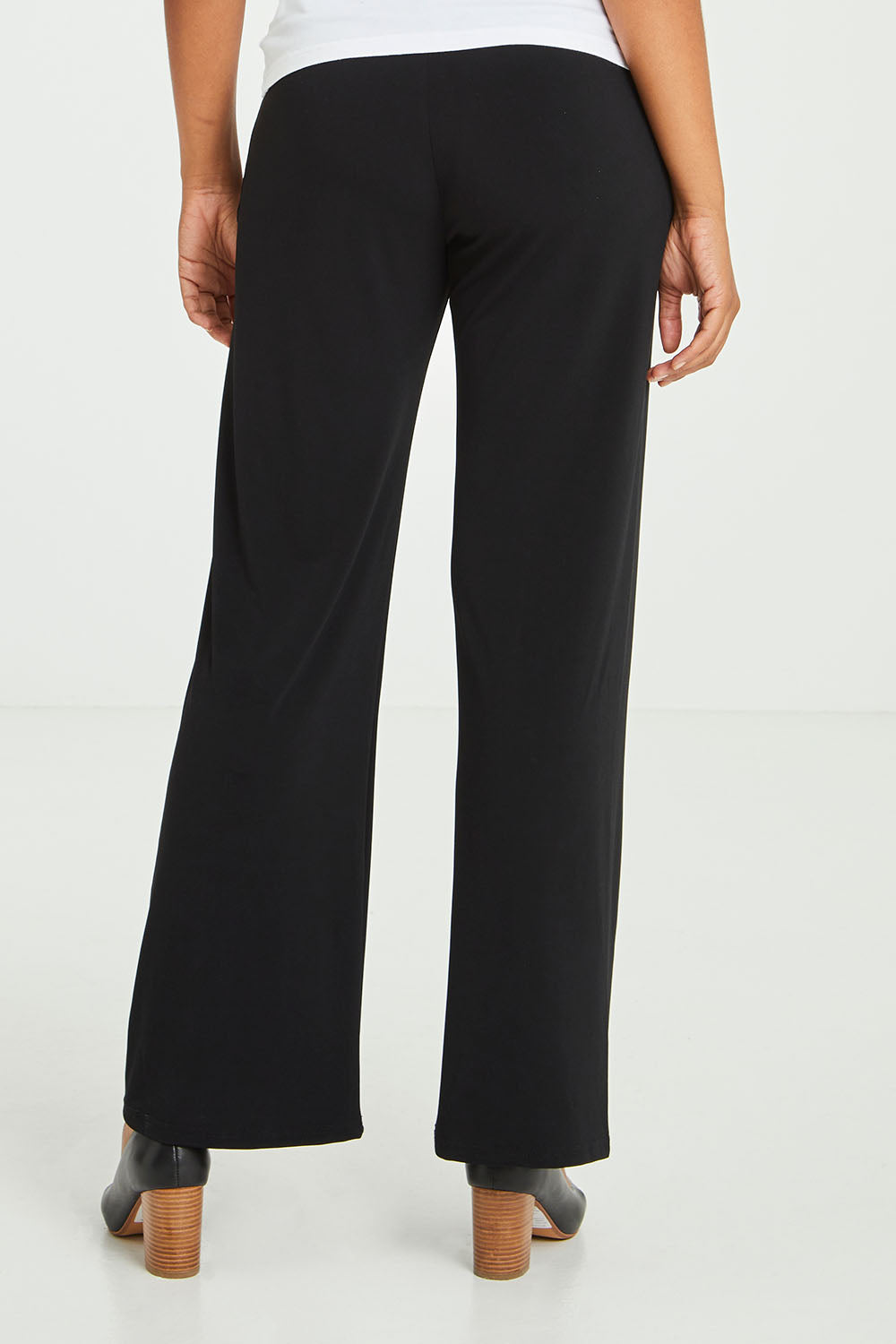 Model Olivia wearing size 10 of The Essential Jersey Pull On Pant in colour Black (Black), from the back