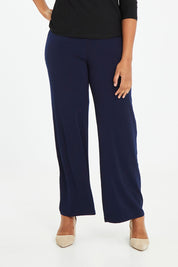Model Noli wearing size 14 of The Essential Jersey Pull On Pant in colour Navy (Blue), from the front, cropped image
