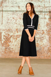 Model Cara wearing size S of The Contrast Trim Knit Dress in colour Darkpine (Green), from the front, showing the whole outfit