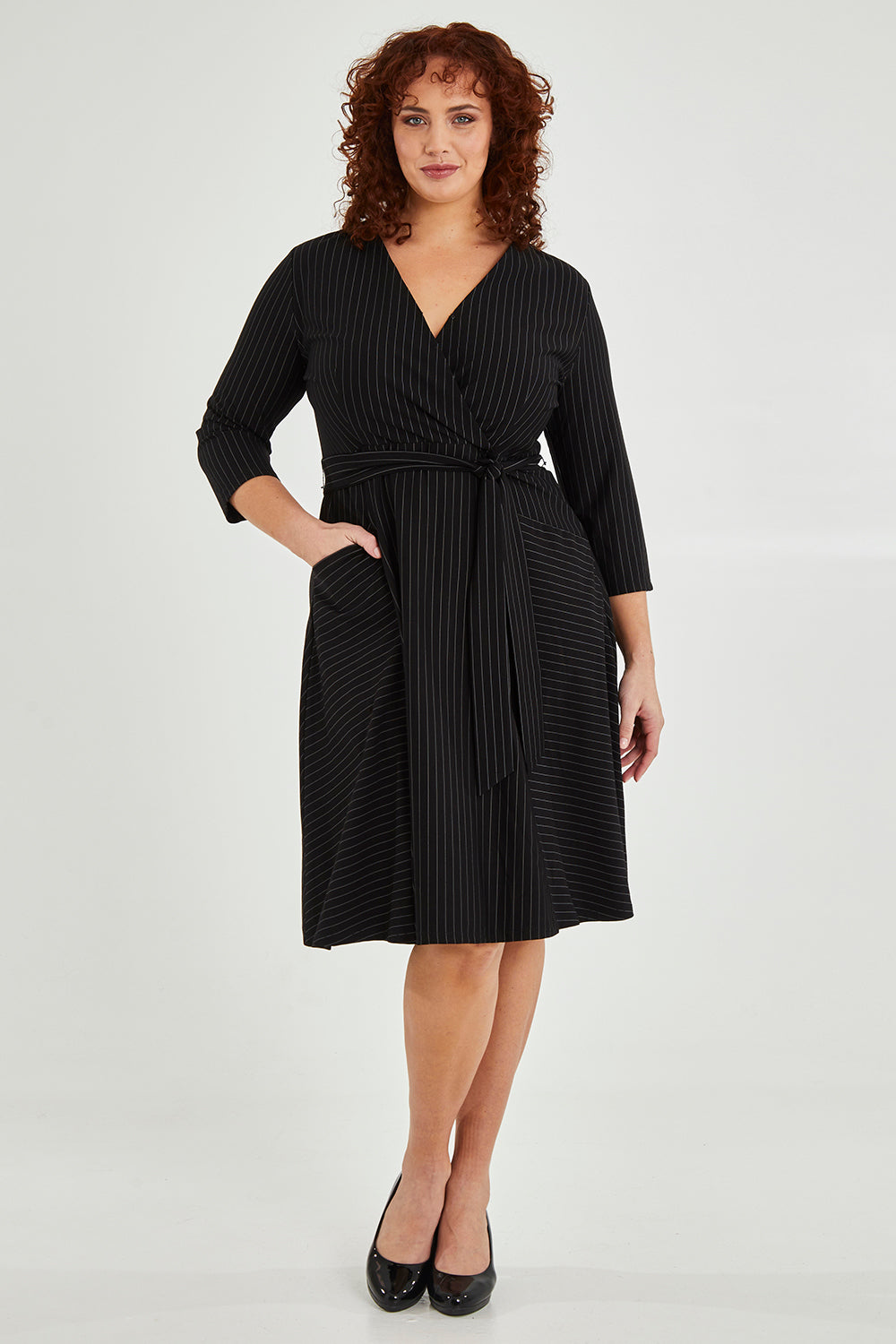 Model Maddy wearing size 16 of The Stripe Ponte Pocket Dress in colour Stripe (Black), from the front, showing the whole outfit