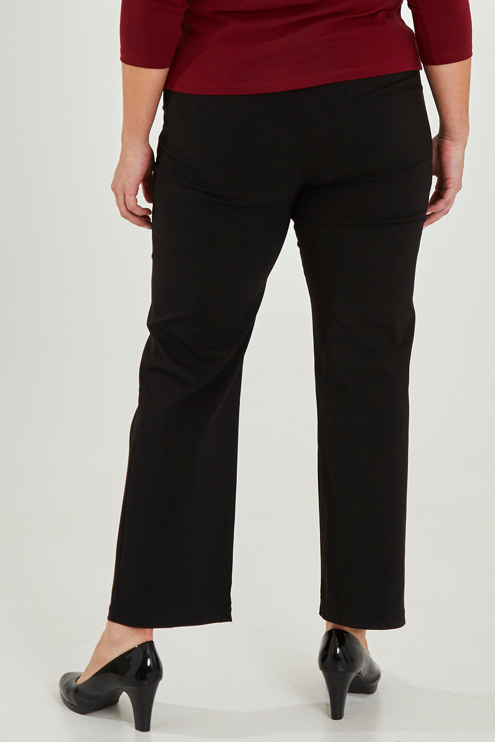 Model Maddy wearing size 16 of The Classic Tailored Stretch Pant in colour Black (Black), from the front, cropped image