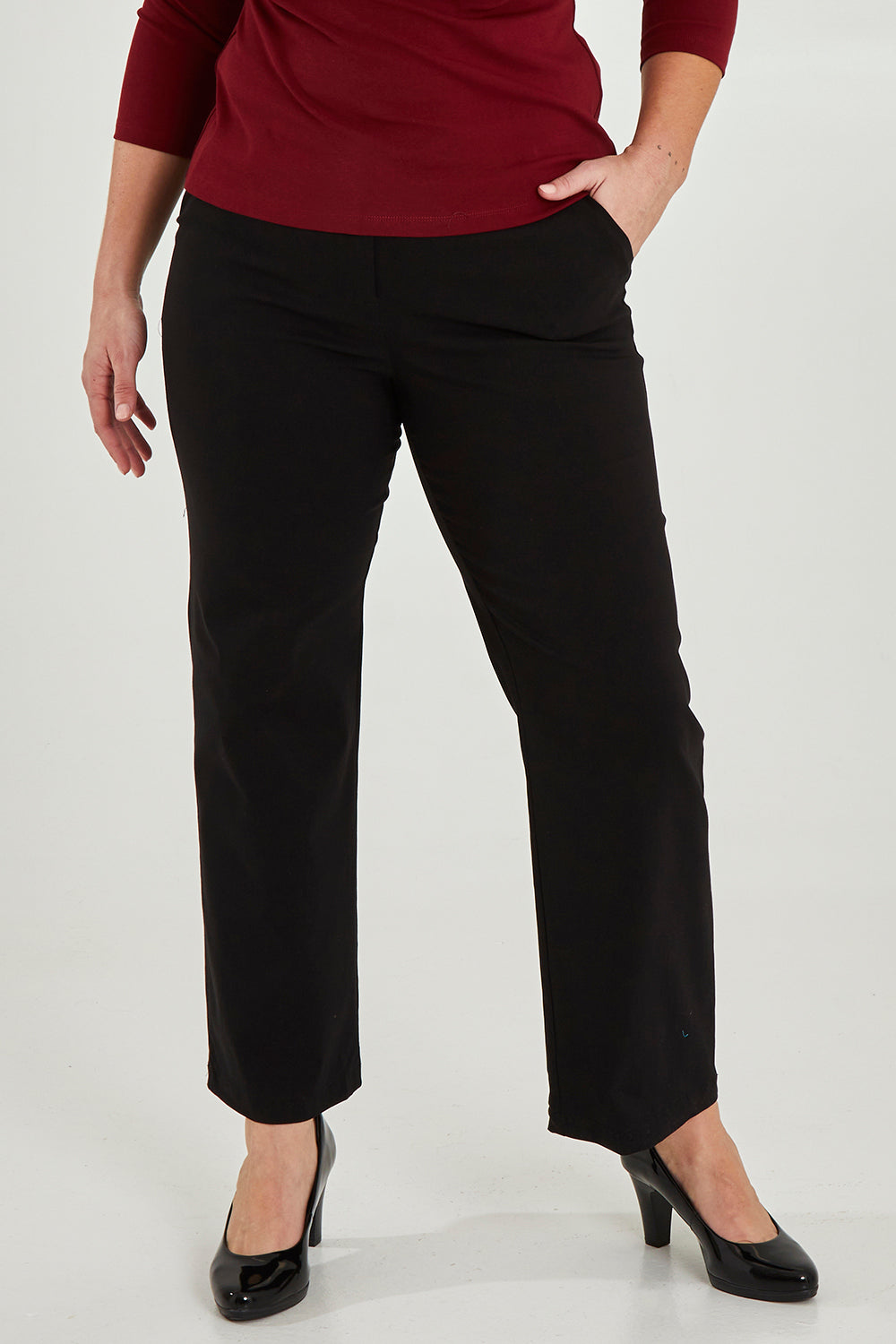 Model Maddy wearing size 16 of The Classic Tailored Stretch Pant in colour Black (Black), from the front, cropped image
