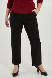 Model Maddy wearing size 16 of The Classic Tailored Stretch Pant in colour Black (Black), from the front, cropped image