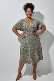 Model Alexis wearing size 16 of the Preloved The Printed Jersey Faux Wrap Dress in colour Fleur (Green), from the front, showing the whole outfit