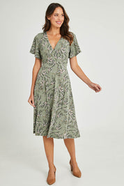 Model Madeline wearing size 10 of The Printed Jersey Faux Wrap Dress in colour Fleur (Green), from the front, showing the whole outfit