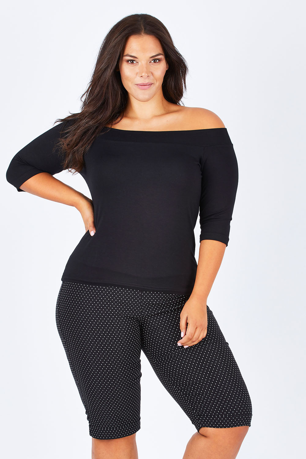 Model Lauren wearing size 16 of the Belle Knee Short in colour Spot (Black), from the front, cropped image