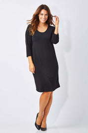 Model Laura wearing size 12 of the Belle Base Layer Dress in colour Black (Black), from the front, showing the whole outfit
